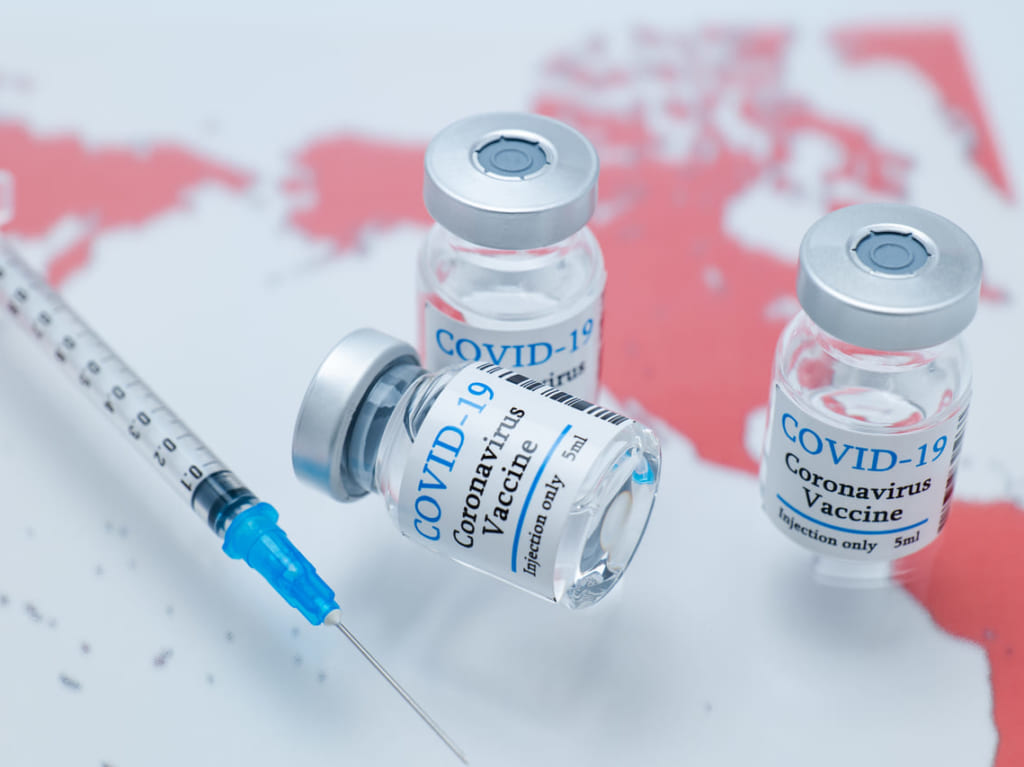 世界地図とコロナウイルスワクチンのイメージ