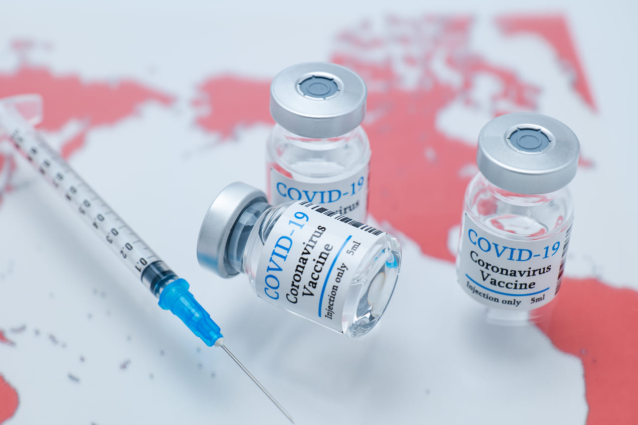 世界地図とコロナウイルスワクチンのイメージ